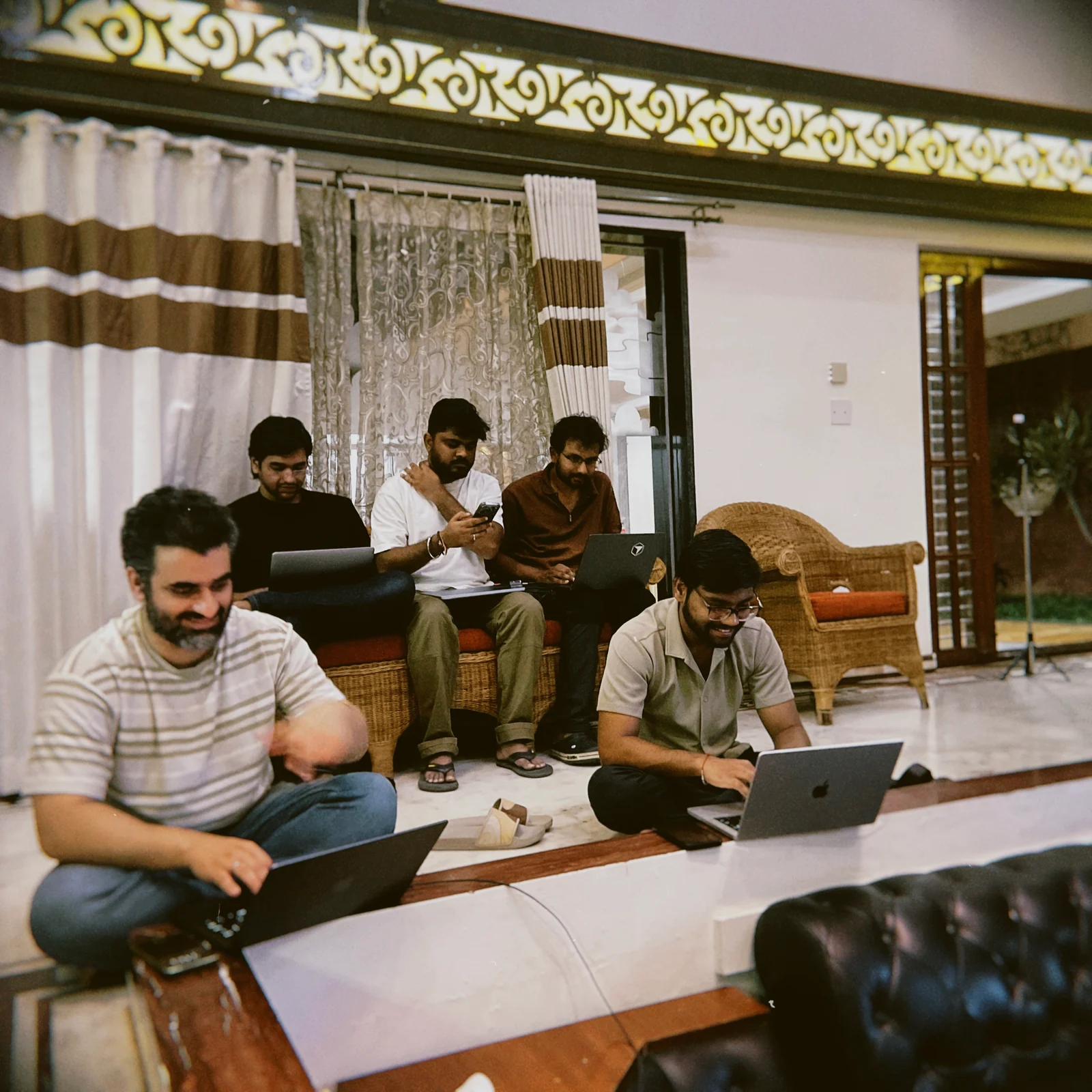 Teammates working on laptops together during an in-person gathering